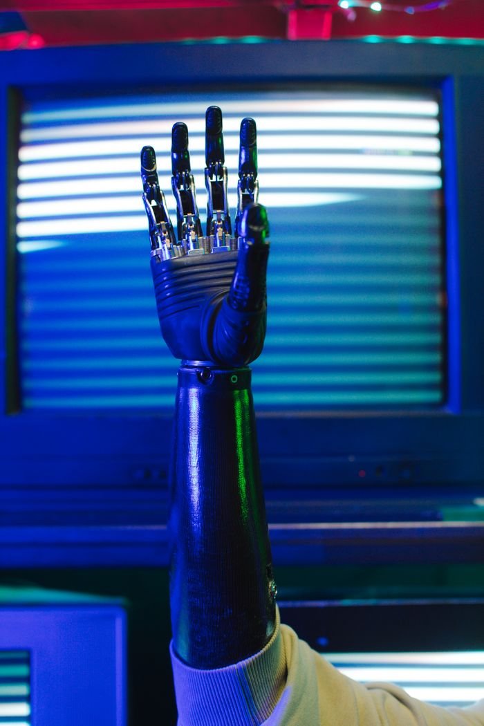 Home Close-up of a bionic prosthetic arm raised against retro tech background.