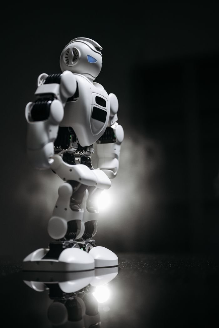 A sleek white robot standing on a reflective surface, exuding innovation and futurism.