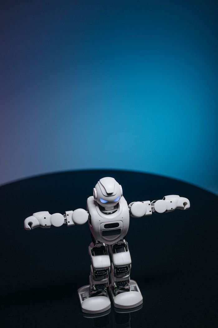 Crafting Captivating Headlines: Your awesome post title goes here White toy robot with glowing eyes posed in a studio setting against a dark background.